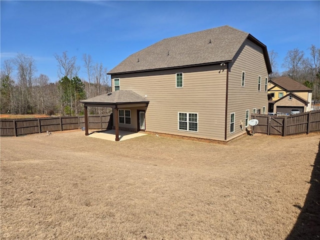 rear view of house with a patio and a fenced backyard