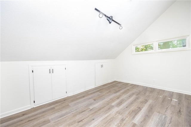 additional living space with lofted ceiling and light wood-type flooring