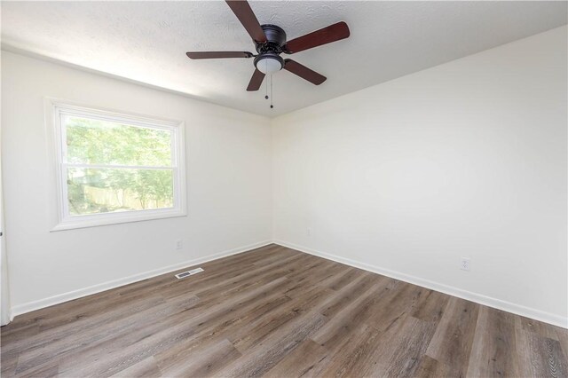 spare room with hardwood / wood-style flooring and ceiling fan