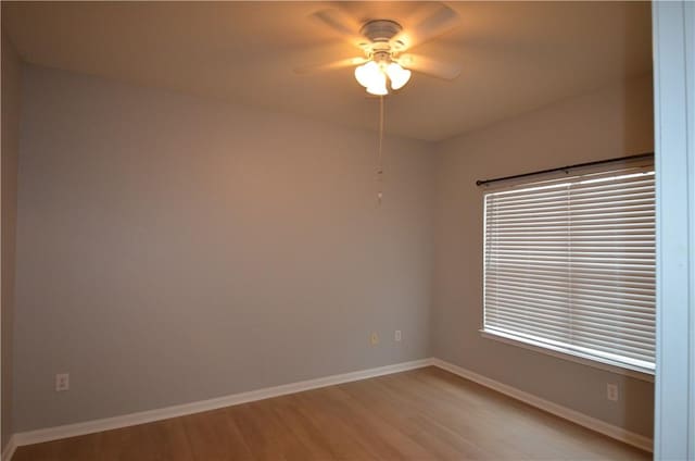 unfurnished room with ceiling fan, light wood-style floors, and baseboards