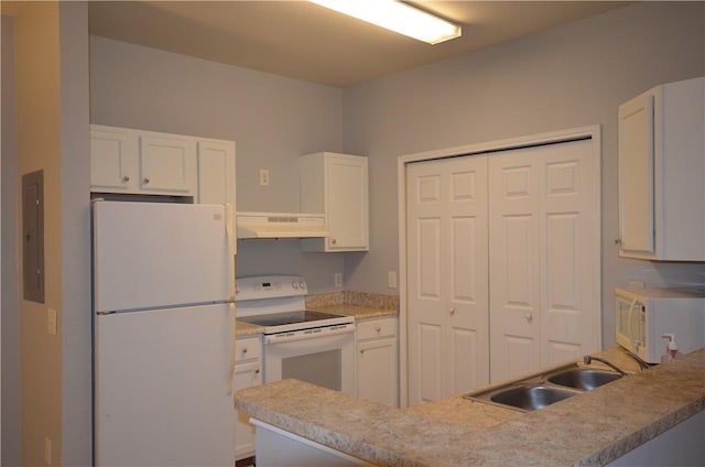 kitchen with white appliances, white cabinets, under cabinet range hood, and a sink