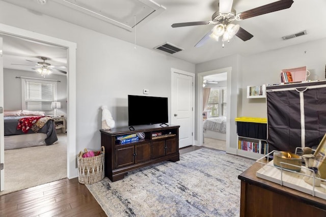 living room featuring ceiling fan and dark hardwood / wood-style flooring