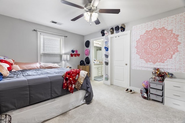 carpeted bedroom featuring ceiling fan and ensuite bath