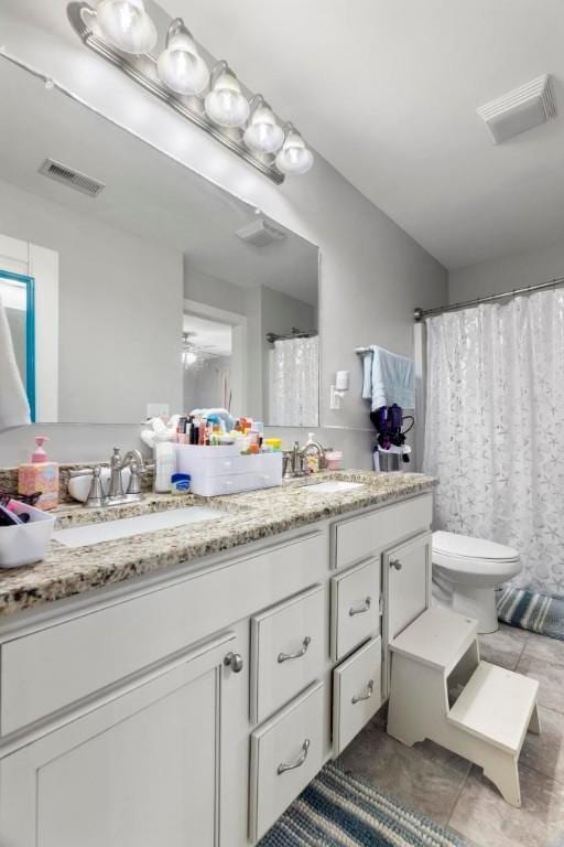 bathroom featuring tile patterned flooring, vanity, and toilet