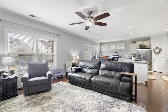 living room with crown molding, ceiling fan, and dark wood-type flooring