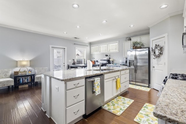 kitchen with appliances with stainless steel finishes, dark hardwood / wood-style flooring, a kitchen island with sink, and white cabinets