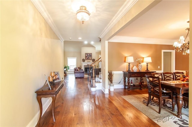 hallway featuring crown molding, hardwood / wood-style flooring, and a notable chandelier