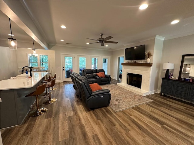 1179 Still Hunt Ln, Auburn, AL 36832 - living area featuring crown molding, a ceiling fan, dark wood-style flooring, recessed lighting, and a brick fireplace