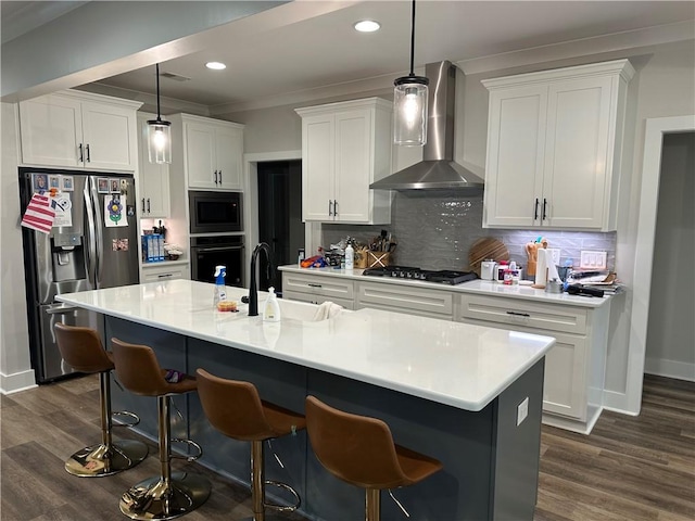 1179 Still Hunt Ln, Auburn, AL 36832 - kitchen featuring wall chimney range hood, appliances with stainless steel finishes, white cabinetry, a breakfast bar area, and recessed lighting