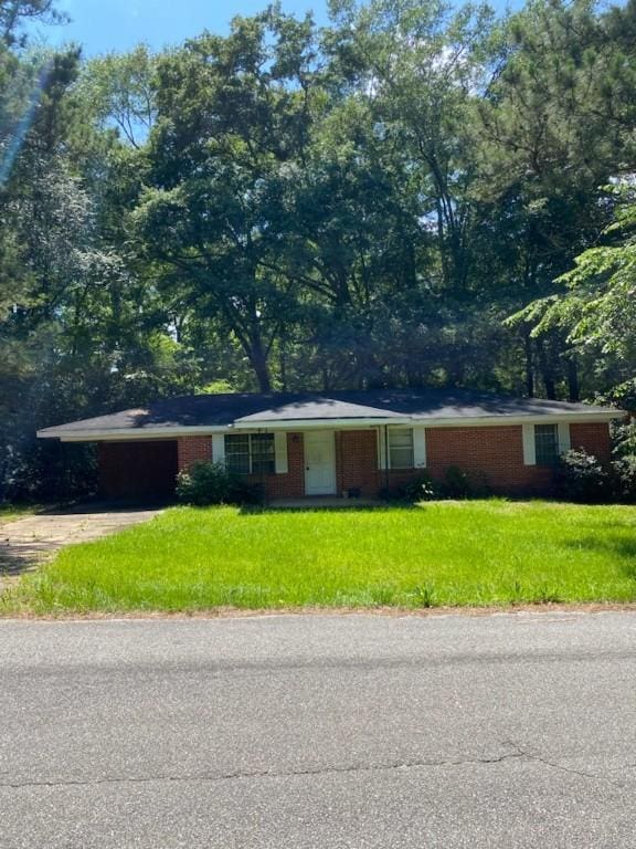 1007 Railroad Ave, Tuskegee, AL 36803 - single story home featuring driveway, a front lawn, brick siding, and an attached garage
