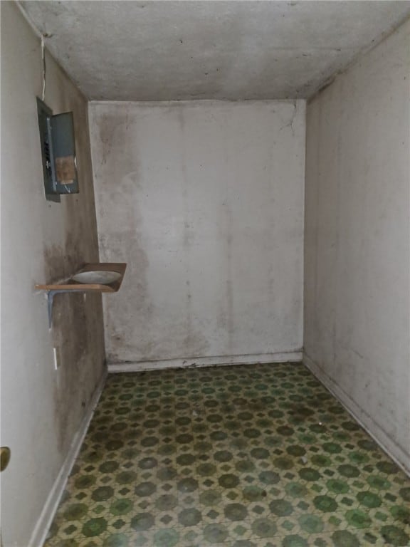 basement with tile patterned floors and electric panel