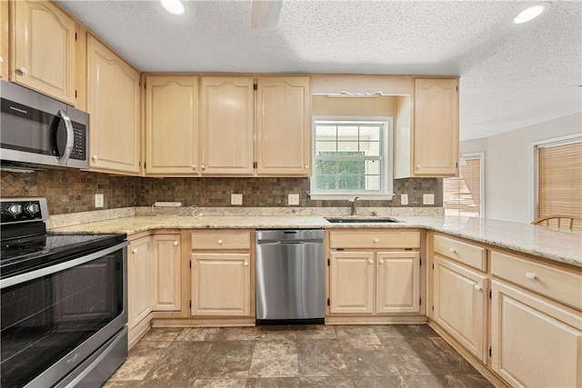 3519 Anderson Rd, Opelika, AL 36801 - kitchen with appliances with stainless steel finishes, light brown cabinetry, a textured ceiling, light stone countertops, and backsplash