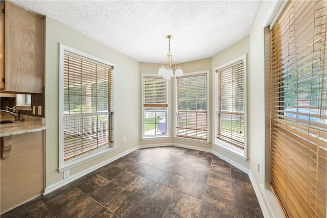 3519 Anderson Rd, Opelika, AL 36801 - unfurnished dining area with a chandelier, a textured ceiling, and dark stone finish flooring