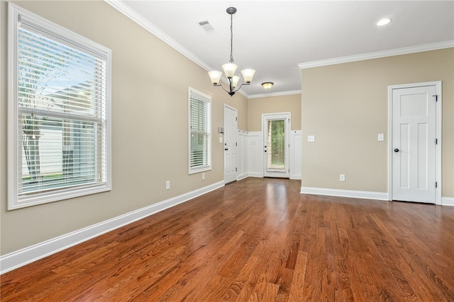 foyer entrance with dark hardwood / wood-style floors, ornamental molding, a wealth of natural light, and an inviting chandelier