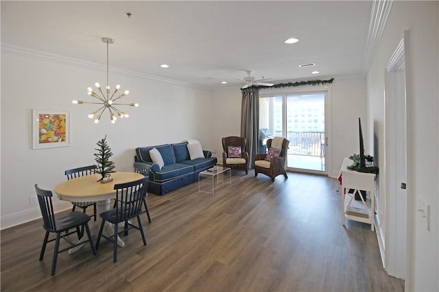 dining room with dark wood-type flooring, ceiling fan with notable chandelier, and ornamental molding