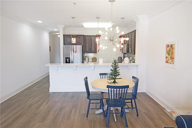 dining room with crown molding, dark hardwood / wood-style flooring, a chandelier, and sink