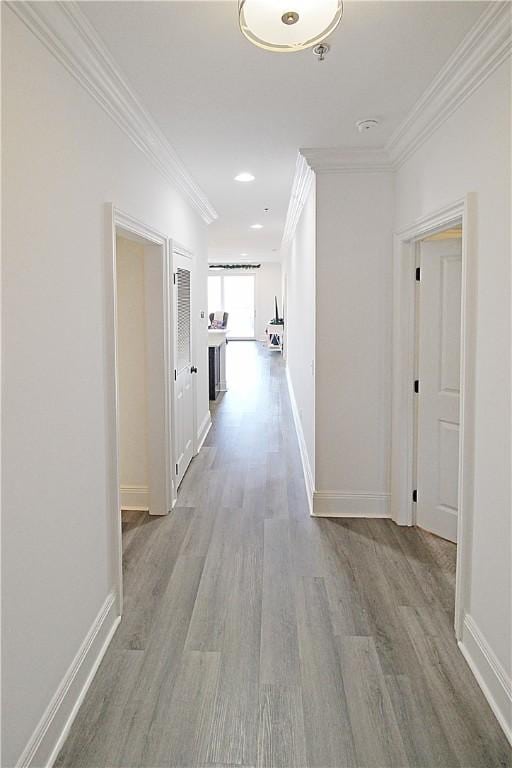 hall with light hardwood / wood-style floors and ornamental molding