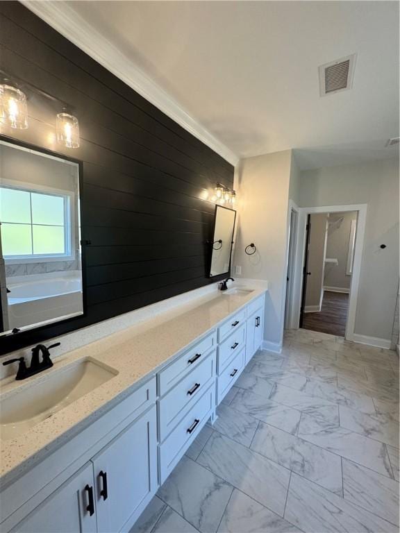 bathroom with crown molding, vanity, and a bath