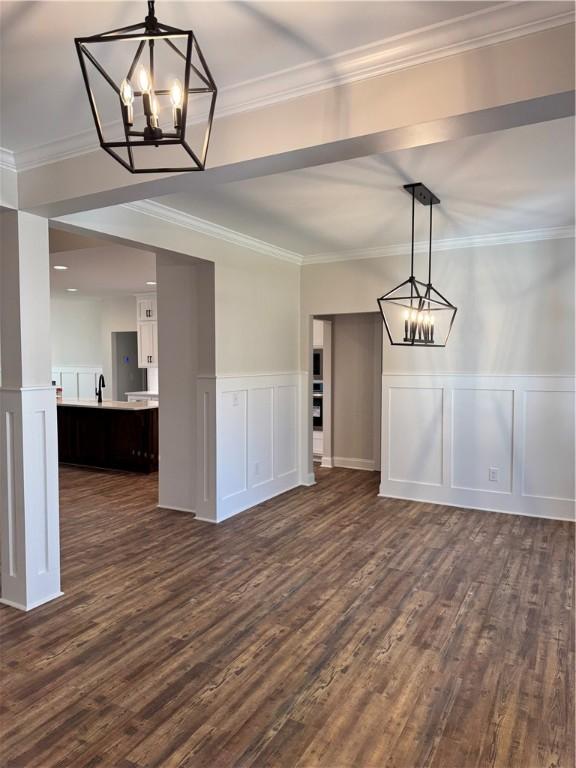 unfurnished dining area with crown molding, dark hardwood / wood-style flooring, and a notable chandelier