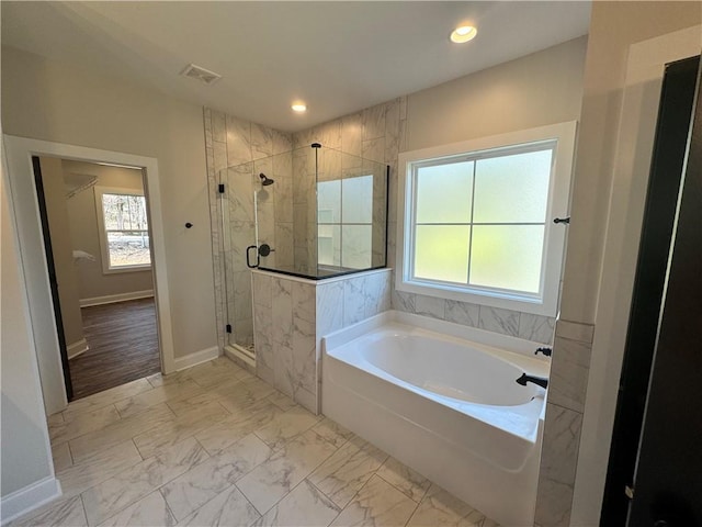 bathroom with shower with separate bathtub and a healthy amount of sunlight