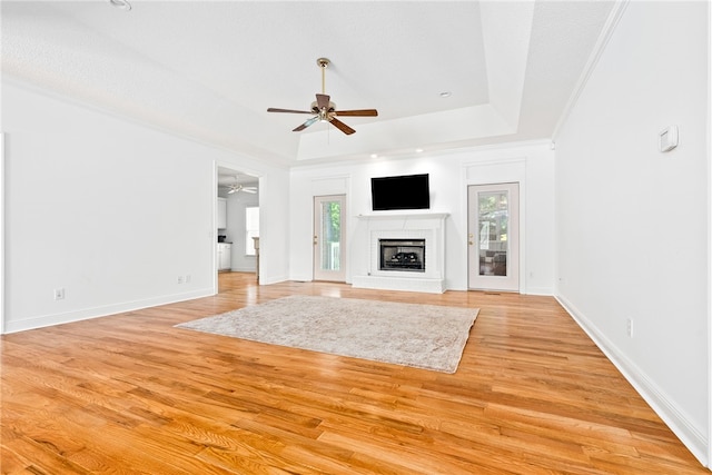 1421 Crossing Way, Auburn, AL 36830 - unfurnished living room with ceiling fan, a raised ceiling, healthy amount of natural light, and light wood-style flooring