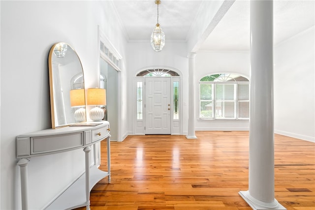 1421 Crossing Way, Auburn, AL 36830 - foyer featuring crown molding, light wood-style floors, ornate columns, and a chandelier