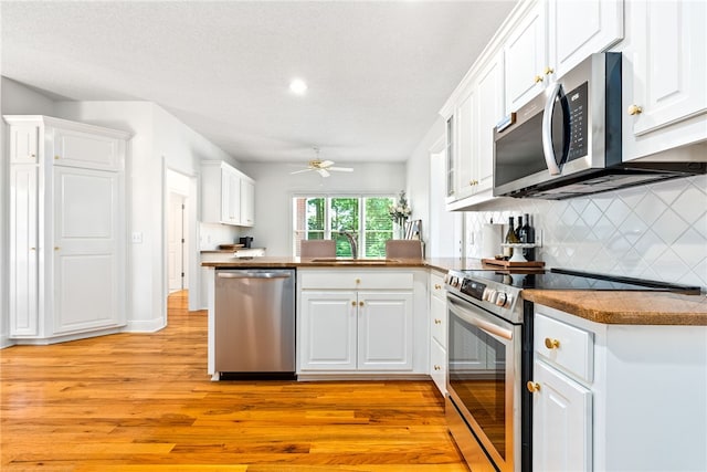 1421 Crossing Way, Auburn, AL 36830 - kitchen with stainless steel appliances, light wood-style floors, a peninsula, ceiling fan, and white cabinetry