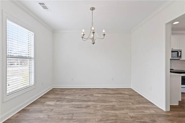 unfurnished dining area with crown molding, wood-type flooring, and a chandelier