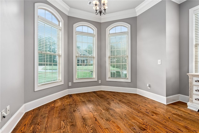 unfurnished dining area with crown molding, wood-type flooring, and a notable chandelier