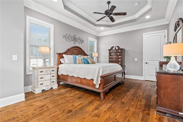 bedroom with a raised ceiling, ceiling fan, crown molding, and dark wood-type flooring