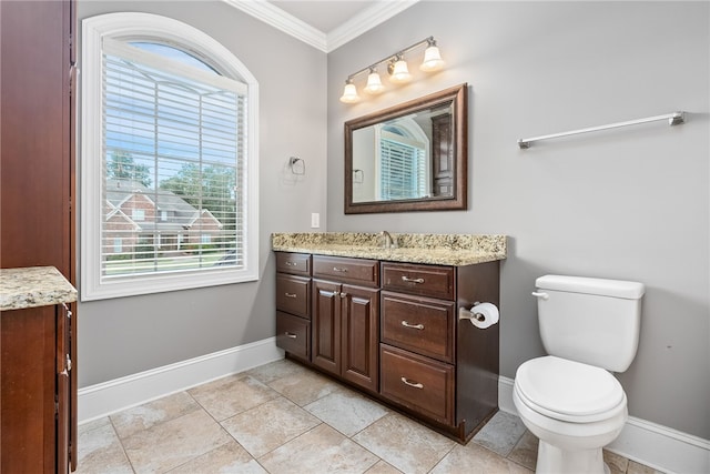 bathroom featuring toilet, vanity, a healthy amount of sunlight, and ornamental molding