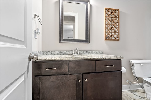 bathroom with toilet, vanity, and baseboards