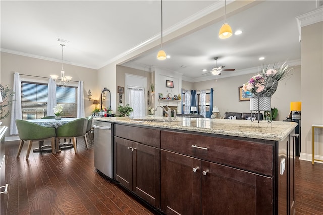 kitchen featuring pendant lighting, a sink, a kitchen island with sink, and light stone countertops