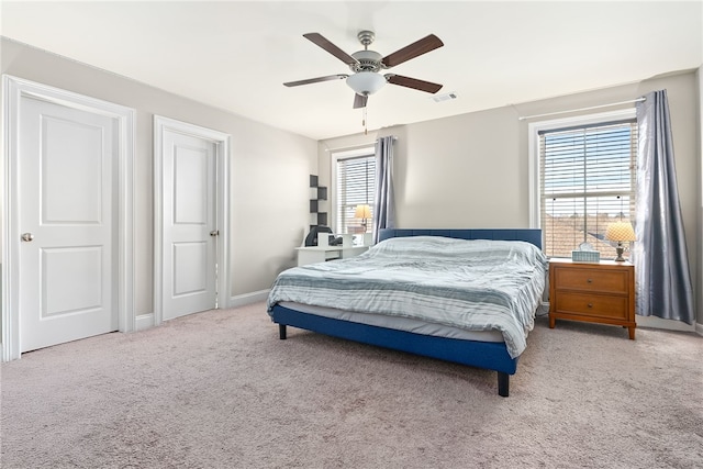 bedroom with visible vents, baseboards, a ceiling fan, and light colored carpet