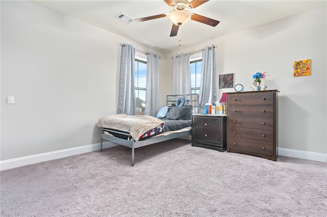 carpeted bedroom featuring baseboards, visible vents, and ceiling fan