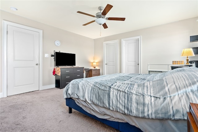 bedroom featuring light colored carpet, ceiling fan, and baseboards