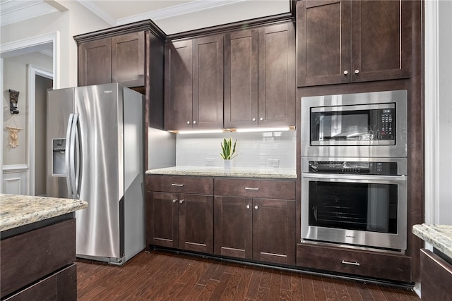 kitchen with tasteful backsplash, dark wood-style floors, light stone counters, stainless steel appliances, and dark brown cabinets