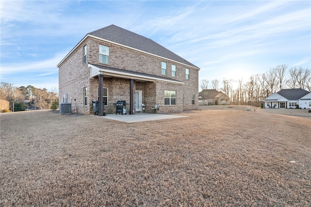 back of house with cooling unit, a patio area, and brick siding