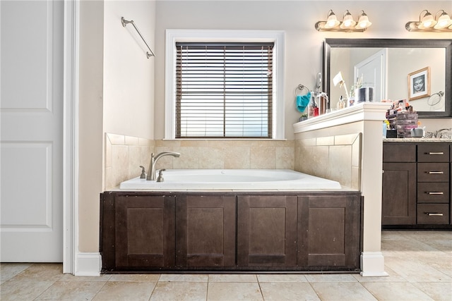 bathroom with a garden tub, vanity, and tile patterned floors