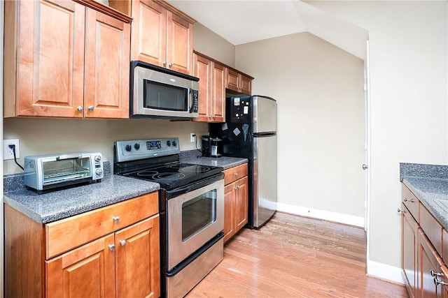 1957 Wire Rd Unit 21, Auburn, AL 36832 - kitchen with appliances with stainless steel finishes, light wood-type flooring, dark countertops, and brown cabinets