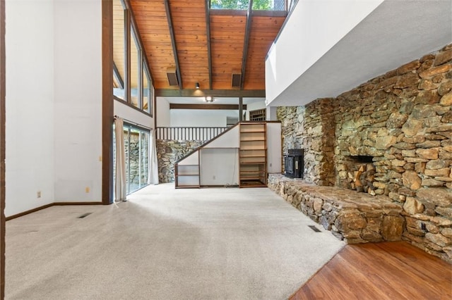 711 Oak Knoll Cir, Auburn, AL 36830 - unfurnished living room with a high ceiling, a wood ceiling with exposed beams, carpet flooring, and a stone fireplace