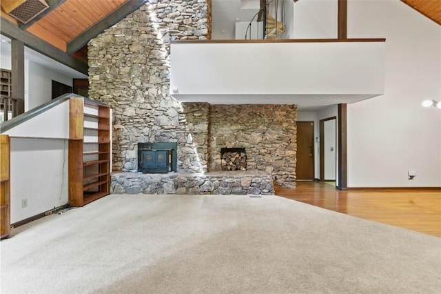 711 Oak Knoll Cir, Auburn, AL 36830 - unfurnished living room with carpet floors, wooden ceiling, a wood stove, high vaulted ceiling, and wood finished floors