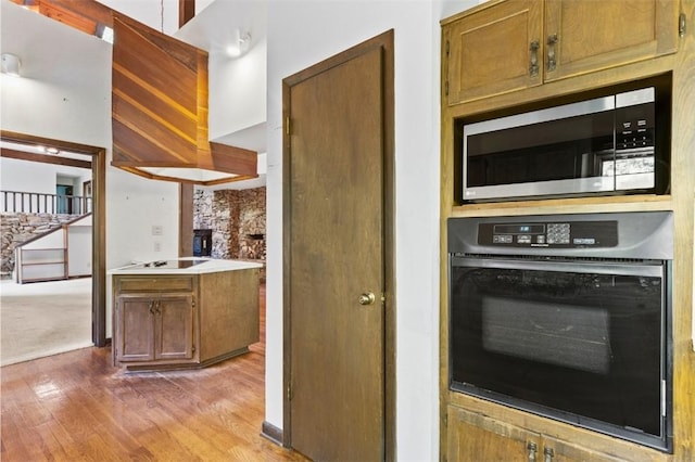 711 Oak Knoll Cir, Auburn, AL 36830 - kitchen with black oven, stainless steel microwave, light wood-style floors, electric stovetop, and light countertops