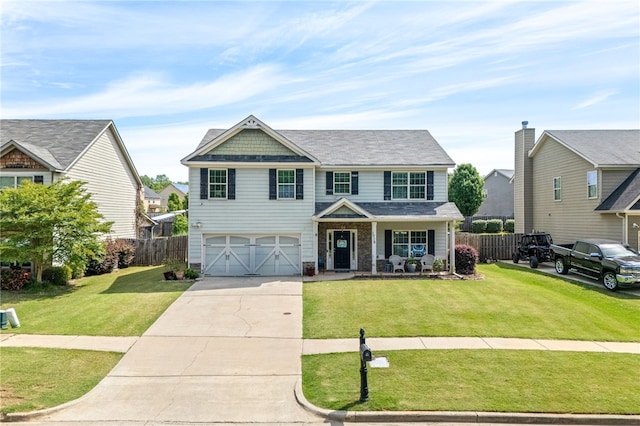 craftsman-style home with fence, concrete driveway, a front lawn, and a garage