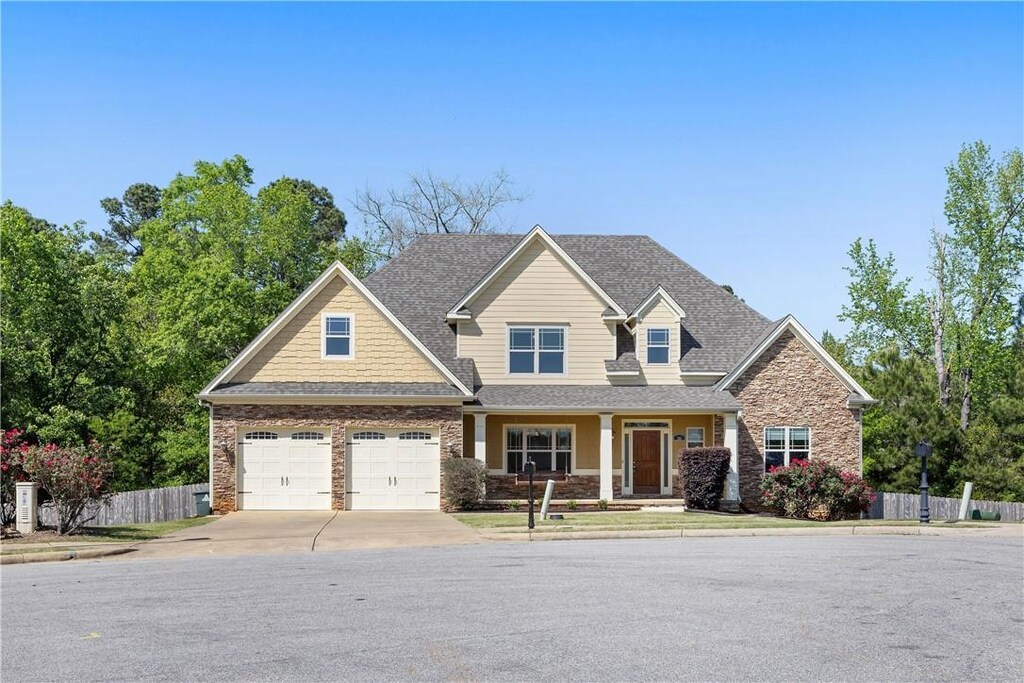 346 Yukon Dr, Auburn, AL 36832 - craftsman house with driveway, a porch, stone siding, fence, and a shingled roof