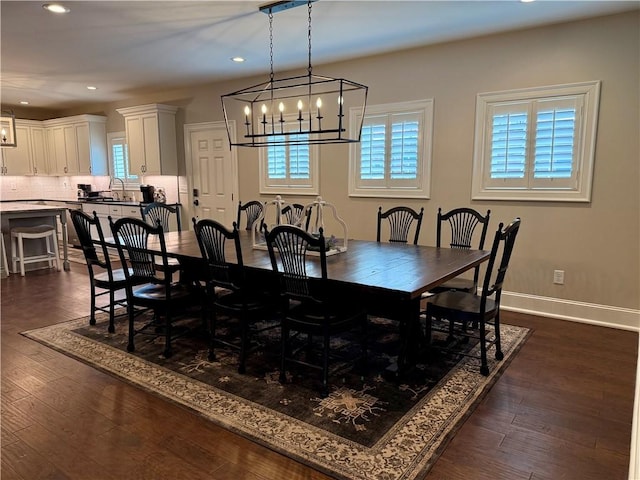 dining area featuring a chandelier, recessed lighting, dark wood-type flooring, and baseboards
