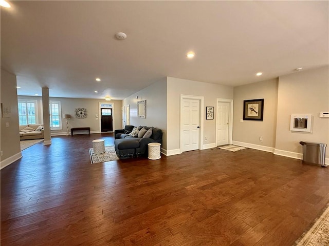 living area with dark wood-style flooring, baseboards, and recessed lighting