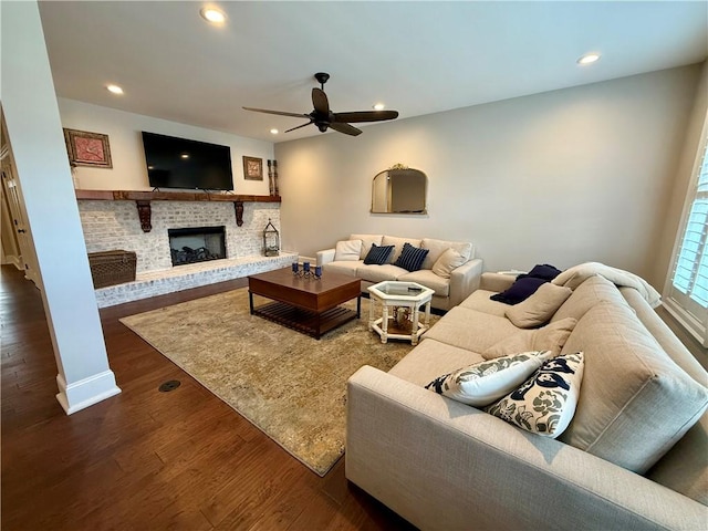 living area with a ceiling fan, recessed lighting, dark wood-style floors, and a fireplace