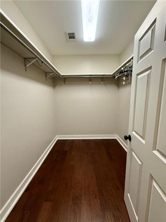 walk in closet with dark wood-type flooring