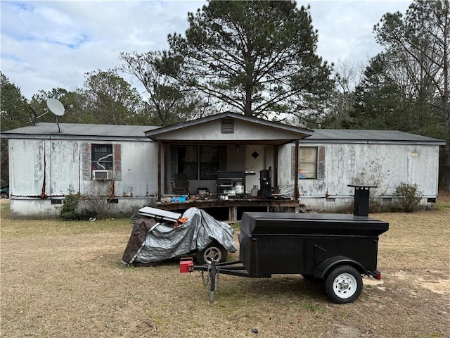 rear view of house featuring a yard and a hot tub